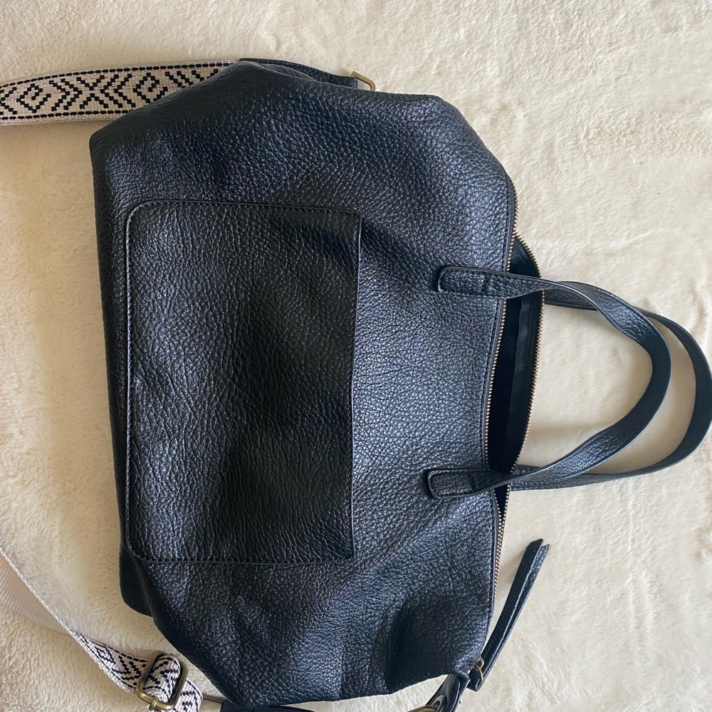 Black leather purse with white cream and black long strap.